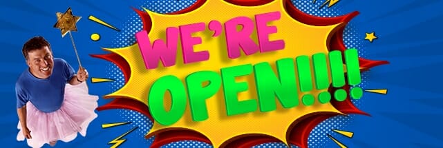 A colorful sign with an "WE'RE OPEN!!!!" announcement features a person in a pink tutu holding a star wand, set against a vibrant backdrop.