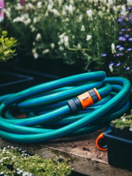 A Hose with Fittings and Tap Connectors 18mmx10m laying on a wooden bench.