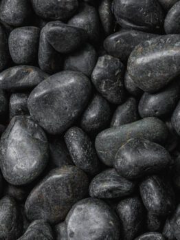 A close-up view of Pebbles Black 30-50mm from a 20kg bag, tightly packed together and highlighting their smooth, polished surfaces.