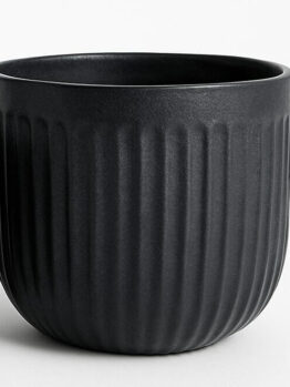 A matt black ceramic planter with vertical ridges, shown empty against a plain background.