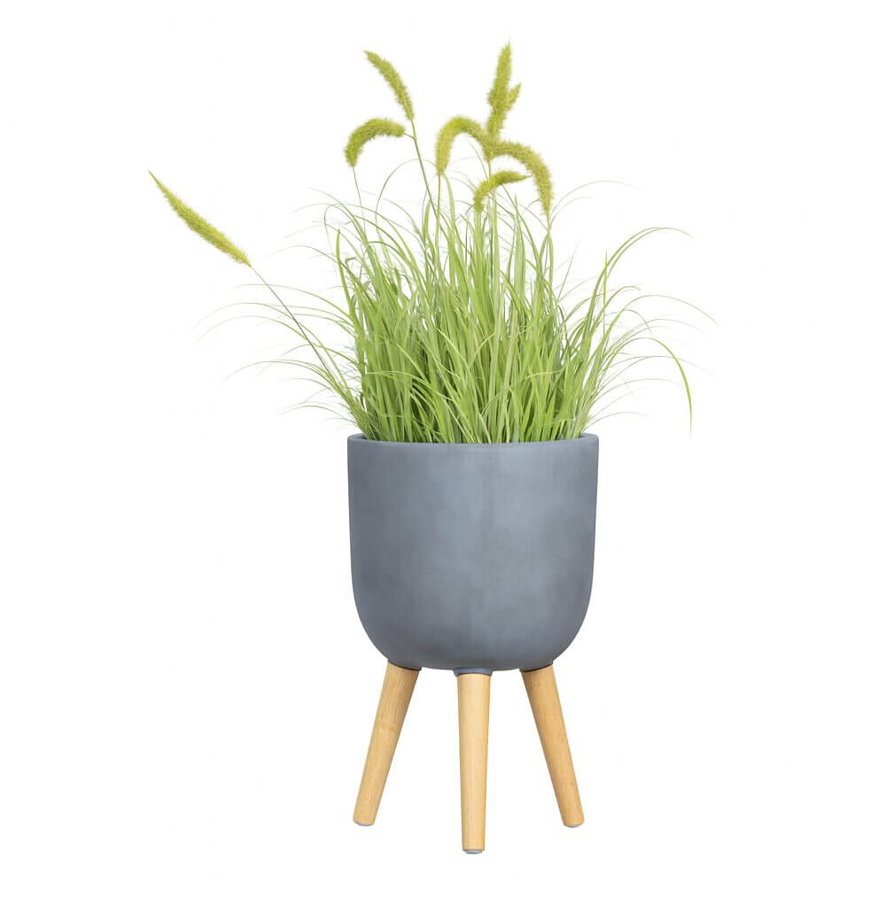 The GardenLite Egg Planter with Legs Brushed Concrete XS 25x25cm features a grey finish and three wooden legs, displaying tall green ornamental grass with fluffy seed heads, set against a white background.