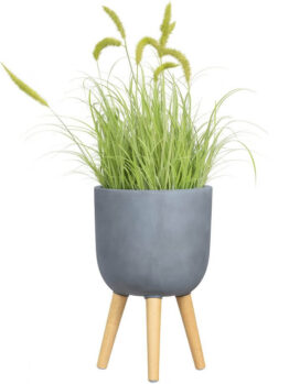 A GardenLite Egg Planter with Legs Brushed Concrete M 39x38cm holds tall, green ornamental grass with feathery seed heads, isolated on a white background.