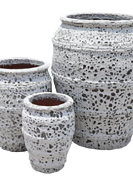 Three textured, white ceramic pots of varying sizes are grouped together against a plain background.