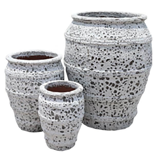 Three textured, white ceramic pots of varying sizes are grouped together against a plain background.