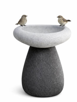 Two small birds perched on the rim of a modern, two-tone stone bird bath against a white background.