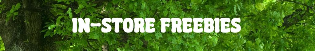 Banner with the text "IN-STORE FREEBIES" in bold white letters over a background of green tree leaves, highlighting the Easter Plant Give-away.