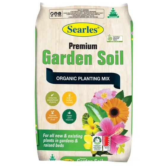 A 30L bag of Searles Premium Garden Soil organic planting mix, featuring images of flowers and product benefits on the packaging.